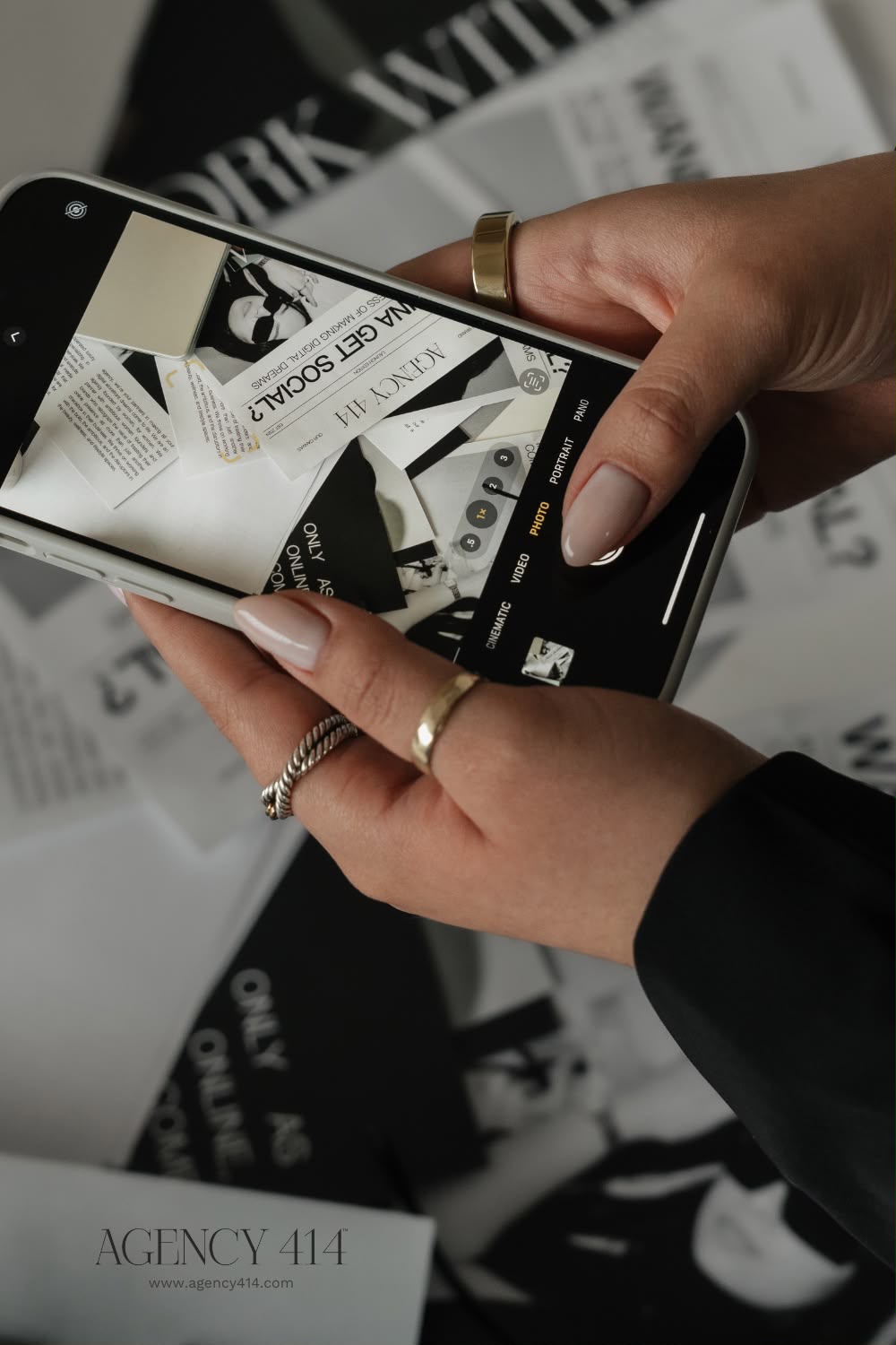 Manos fotografiando materiales de branding con un celular.